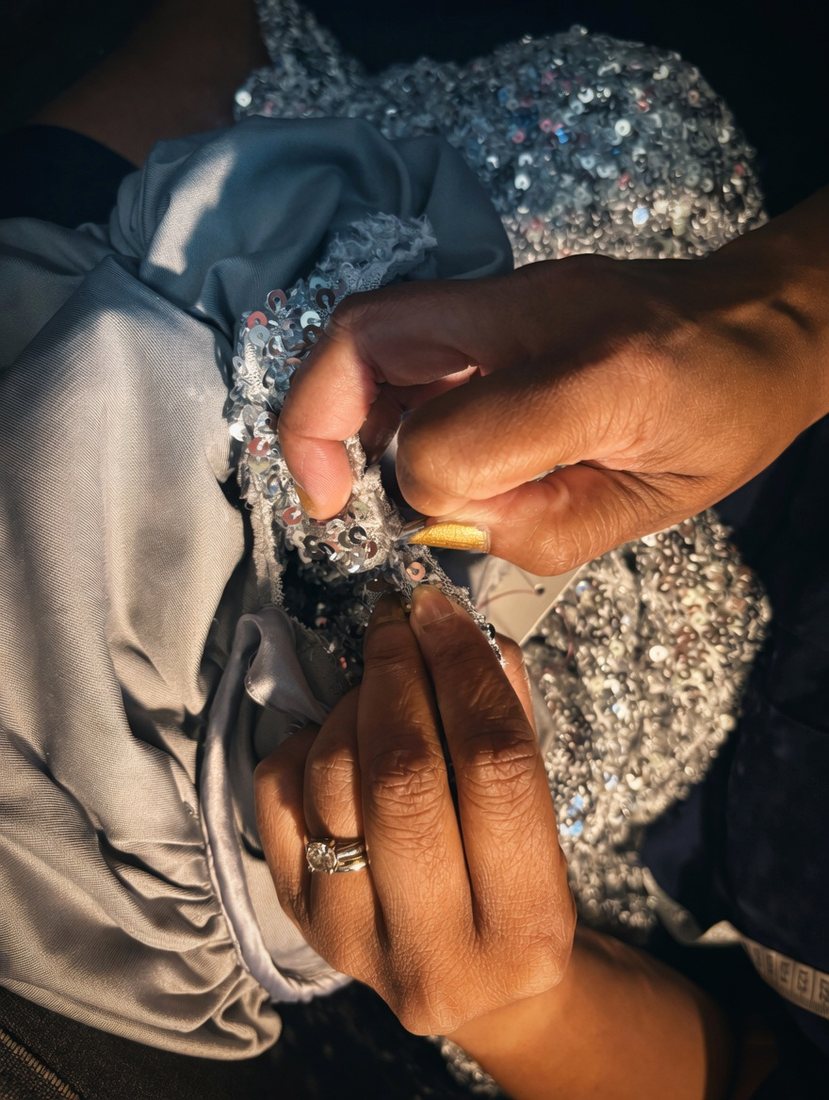 Hand-sewing sequins onto a gown